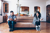 Couple with relationship difficulties sitting on sofa at home