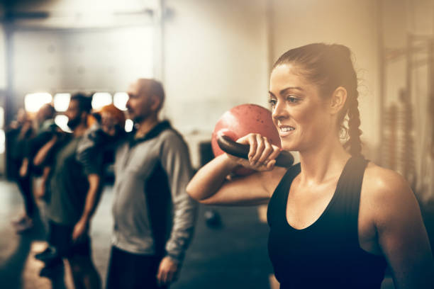 istock Fit woman working out with weights in an exercise class 924961642