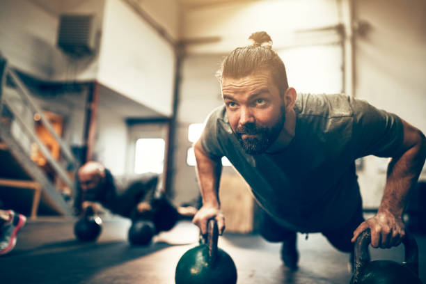 istock Fit young man doing pushups with weights at the gym 924961804