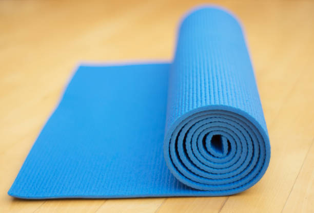 istock Rolled blue exercise mat for Yoga or Pilates on wooden floor 924962270