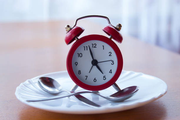 istock Red alarm clock on a plate with spoon 924962556
