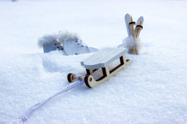 Decorations of ski with poles and a sleigh and skates on real snow.
