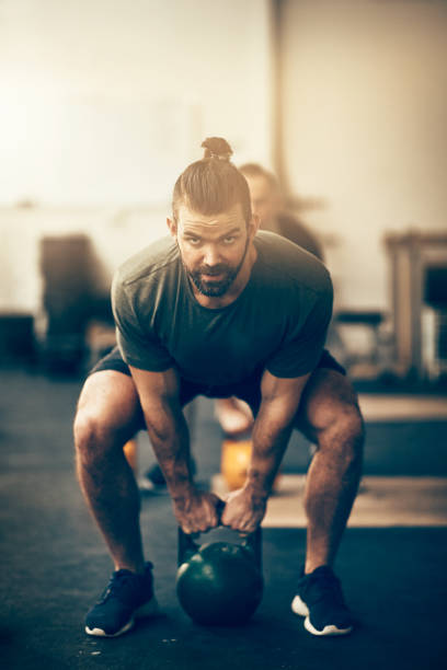 istock Man lifting dumbbells during an exercise class at the gym 924962932