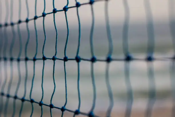 blurred volleyball net on the beach, blue