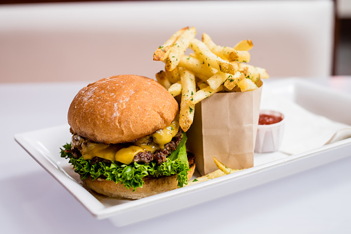 gourmet hamburger and fries with drinks on the side