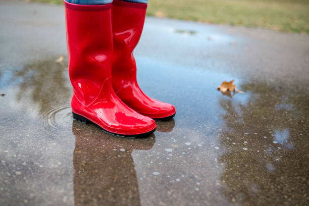 istock Rubber boots are jumping into a big puddle with splash. 924977604