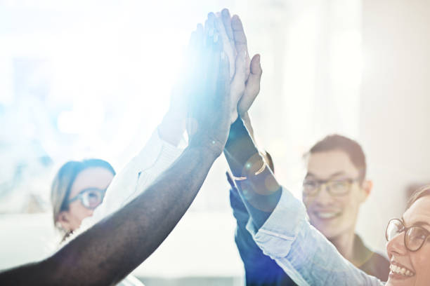 istock Smiling work colleagues high fiving together in a modern office 924978836