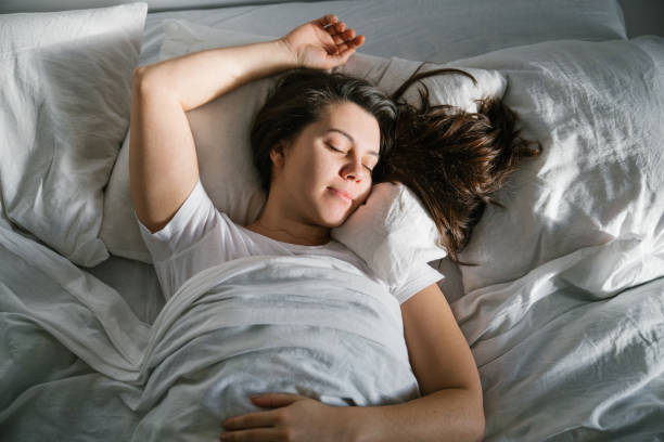 istock woman sleep in bed sunshine thought the window 924978956