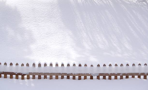 Sunny Snow Shadows and a Fence stock photo