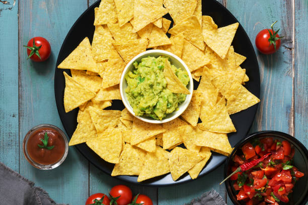 istock Mexican nachos chips with salsa sauce and guacamole on rustic background. 924986558
