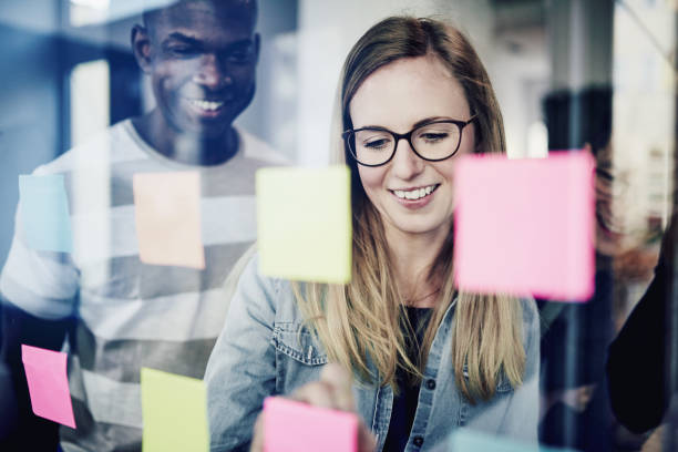istock Diverse businesspeople brainstorming with sticky notes on a glass wall 924986678