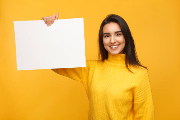 istock Bright woman in yellow with blank paper 924989848