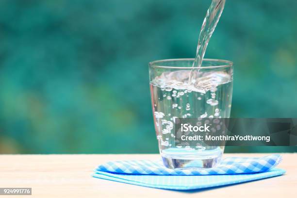 Closeup Glass De Agua Sobre Fondo De Naturaleza De Mesa Foto de stock y más banco de imágenes de Agua