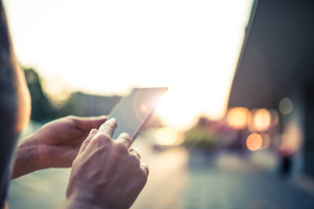 mujer usando su teléfono móvil en la calle - mobile marketing fotografías e imágenes de stock