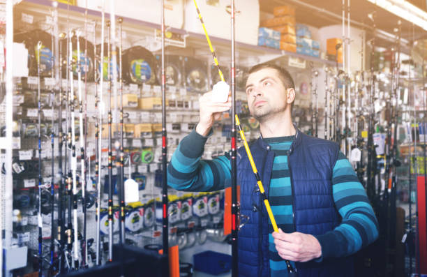 istock Fisherman consumer choosing ocean fishing rod 924994892