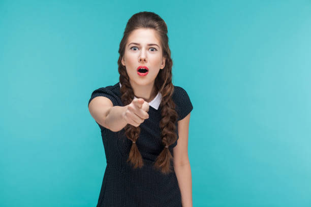 istock Surprised young woman pointing finger at camera and shocked. 925000636