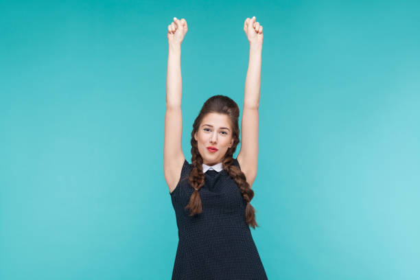 Victory! Successful young woman rejoicing her win. Indoor, studio shot on blue background