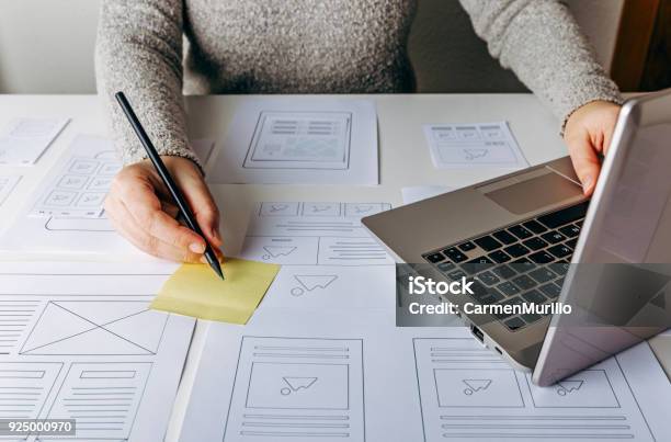 Web Designer Working At Laptop And Website Wireframe Sketches Stock Photo - Download Image Now