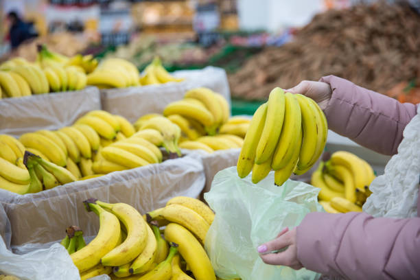 istock customer admires ripe bananas of bananas 925001022