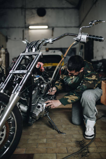 istock Man worker in motorcycle repair shop 925004680