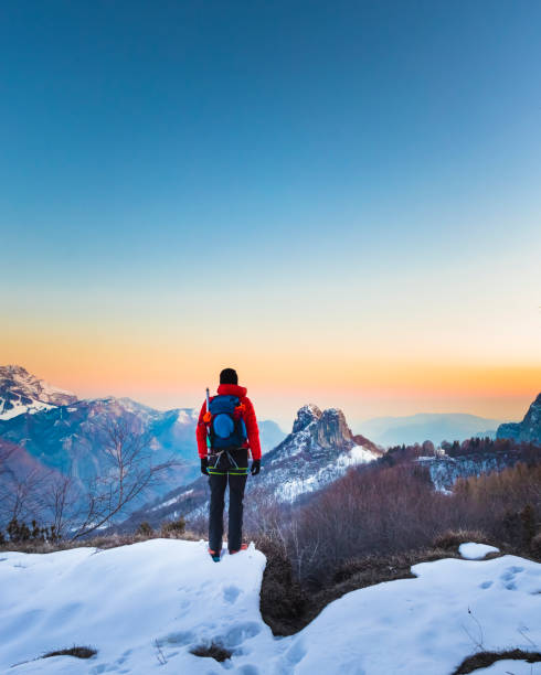 escursionista che guarda la vista sulle montagne all'alba - snow hiking foto e immagini stock