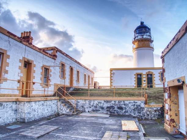 istock Old lighthouse on Neist Point, abandoned  building with tower against to evening sky 925005934