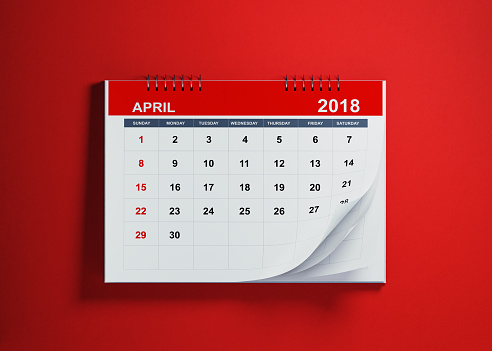 Pages of a red calendar on blue background are folding.  April page. Horizontal composition with copy space. Calendar and reminder concept.