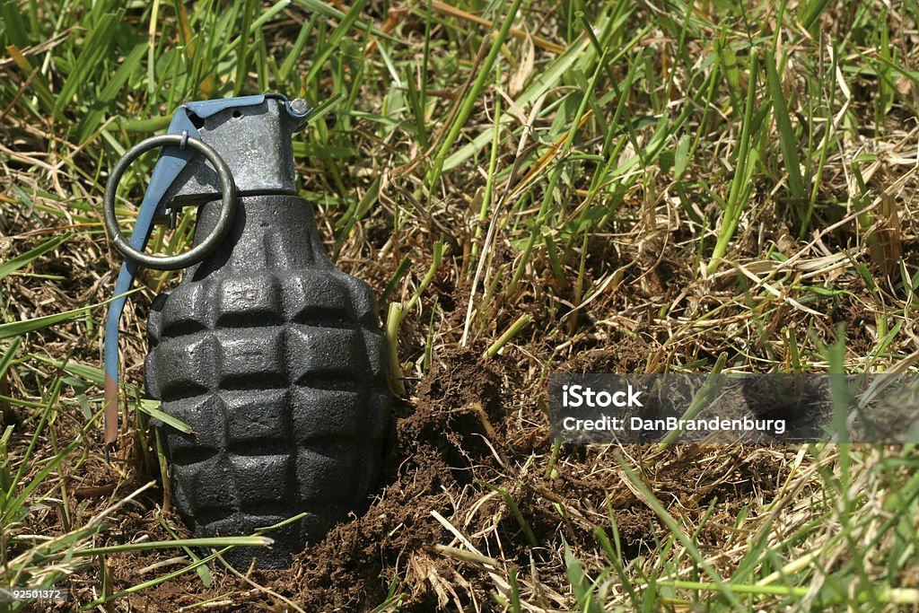 Grenade in Mud grenade in dirt, ready to explode Aiming Stock Photo