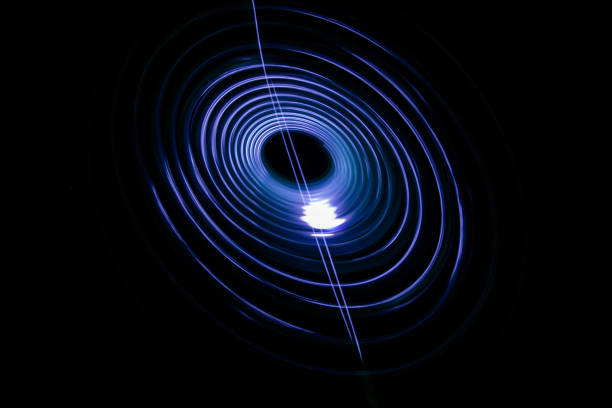 istock Painting with light coming from the diode. A spiral outline drawn by a flashlight suspended on a string. Black background. 925021230