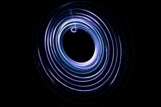 istock Painting with light coming from the diode. A spiral outline drawn by a flashlight suspended on a string. Black background. 925021376