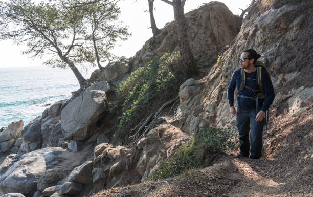 istock man walking among the rocks near a beach paradise 925021498