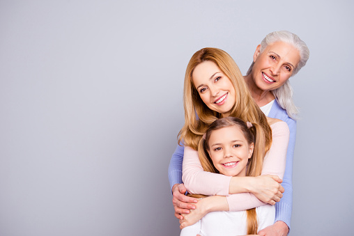 Portrait of charming beautiful friendly king supportive cute family members hugging each other isolated on gray background copyspace