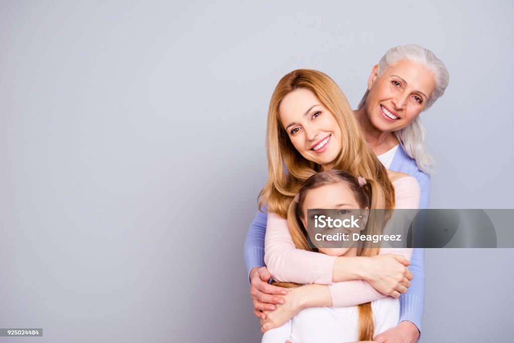 Portrait of charming beautiful friendly king supportive cute family members hugging each other isolated on gray background copyspace Family Stock Photo