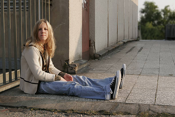 Photo of young beautiful girl taking a rest from the shopping, sitting on the bench and drinking coffee