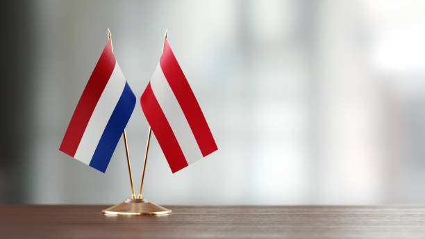 istock Dutch And Austrian Flag Pair On A Desk Over Defocused Background 925028208