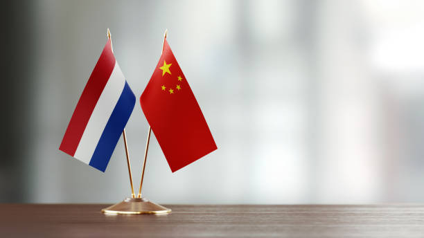 istock Dutch And Chinese Flag Pair On A Desk Over Defocused Background 925028648