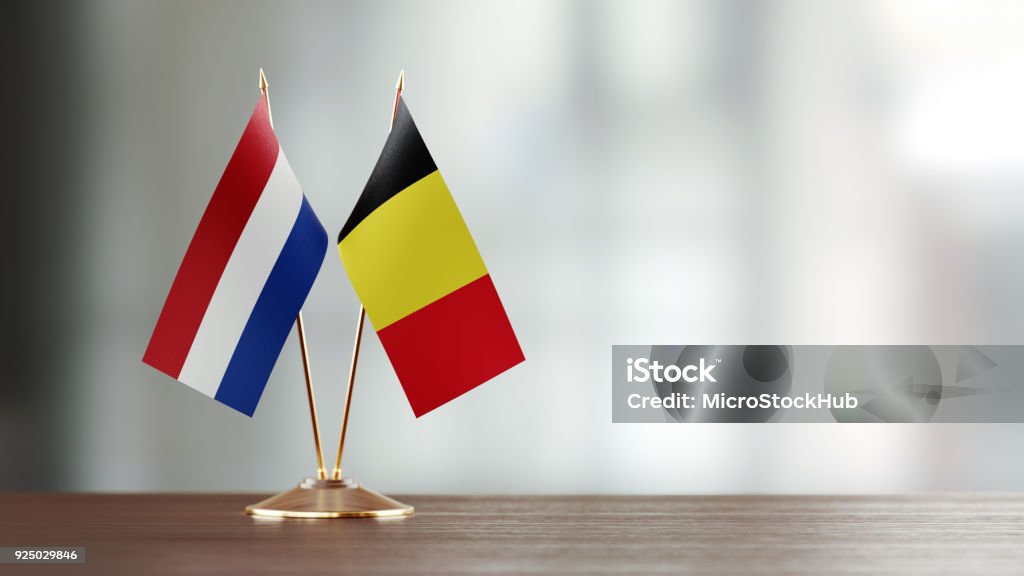 Niederländische und belgische Flagge paar auf einem Schreibtisch über defokussierten Hintergrund - Lizenzfrei Belgien Stock-Foto