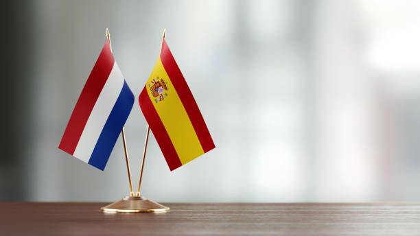 istock Dutch And Spanish Flag Pair On A Desk Over Defocused Background 925030050
