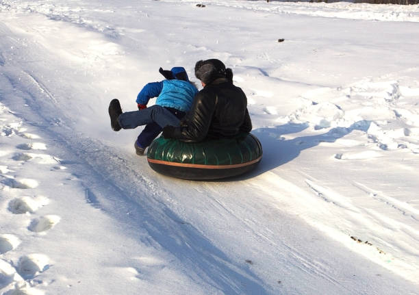 istock A man is riding a child on inflatable sleighs in the snow. 925032878