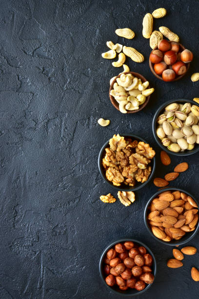 istock Assortment of nuts on  a black slate or stone background 925033900