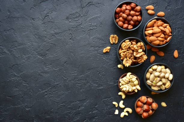 istock Assortment of nuts on  a black slate or stone background 925033906