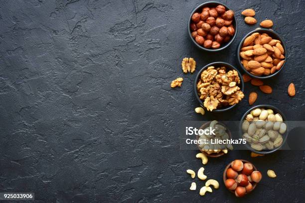 Assortment Of Nuts On A Black Slate Or Stone Background Stock Photo - Download Image Now