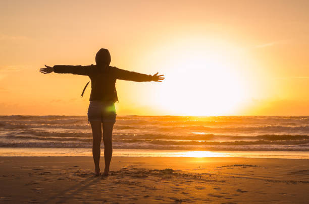 Woman looking at the horizon Woman looking at the horizon, beach at sunset walking beach women sadness stock pictures, royalty-free photos & images