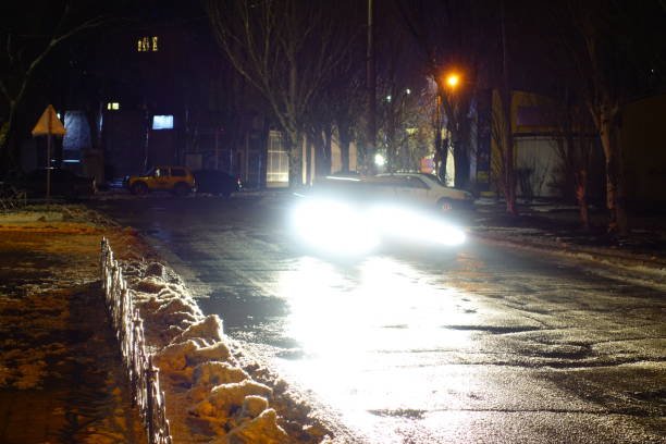 istock Light from car headlights at winter night. 925051560