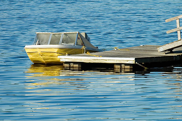 old yellow speedboat at dock stock photo