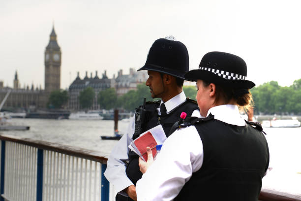 London Police Police officers from the London Police standing alongside the river Thames with Big Ben in the background in London, England, United Kingdom. metropolitan police stock pictures, royalty-free photos & images