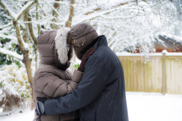 Young couple hugging and kissing in Christmas decorated city at night