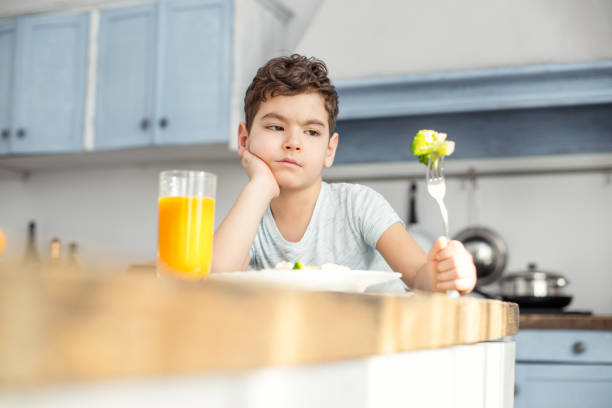 istock Unsmiling boy eating vegetables for breakfast 925064892