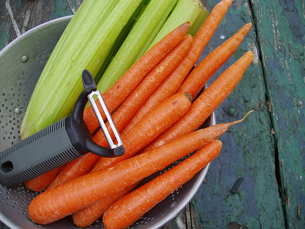 karotten und sellerie & mit peeler-frisches gemüse - nutritian stock-fotos und bilder