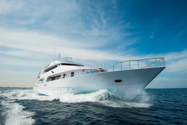 Luxury private motor yacht sailing at sea A luxury private motor yacht under way on tropical sea with bow wave yacht stock pictures, royalty-free photos & images